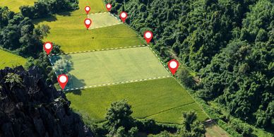 Aerial view of farmland with digital location markers on fields.