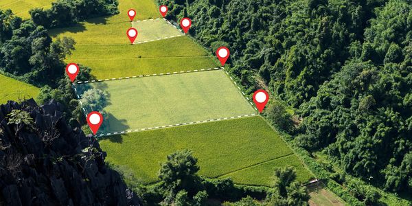 Aerial view of farmland with digital location markers on fields.