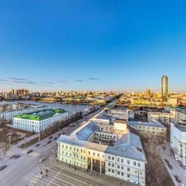 Cityscape with clear blue sky and urban buildings at sunset.