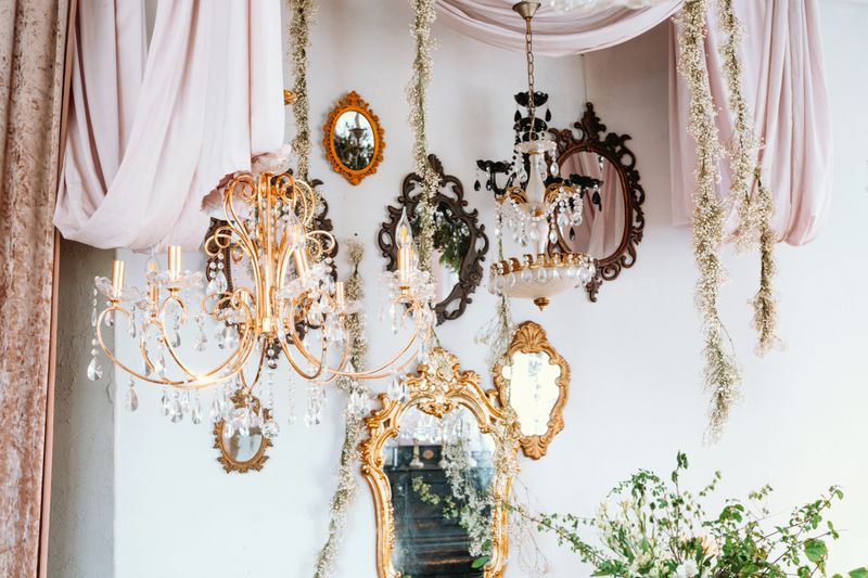 Chandeliers and ornate mirrors create a stylish atmosphere in a cozy dining area.