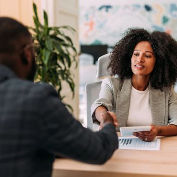 Two professionals shaking hands in an office.