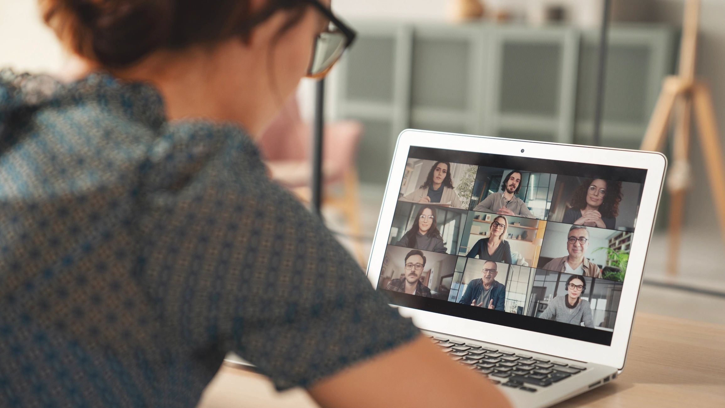 Person attending a video conference call on a laptop with nine participants.