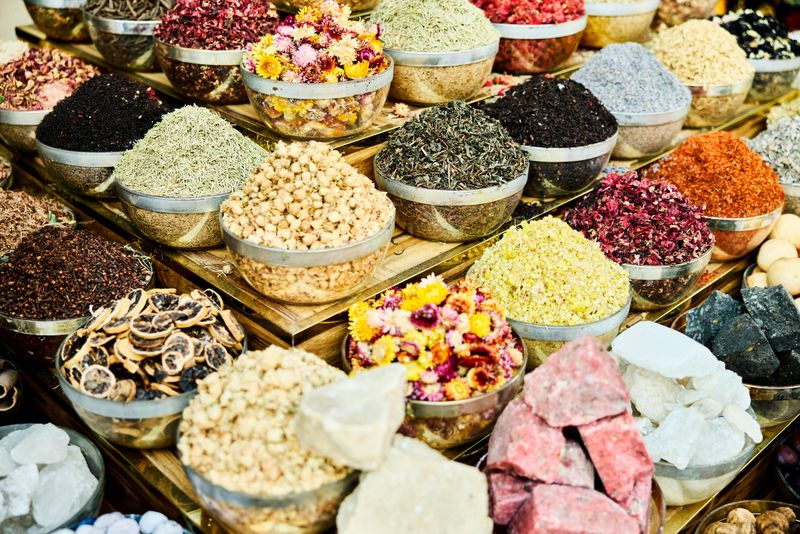 Variety of colorful spices arranged at stall. Dyes are arranged on shop display. They are arranged in bowls.