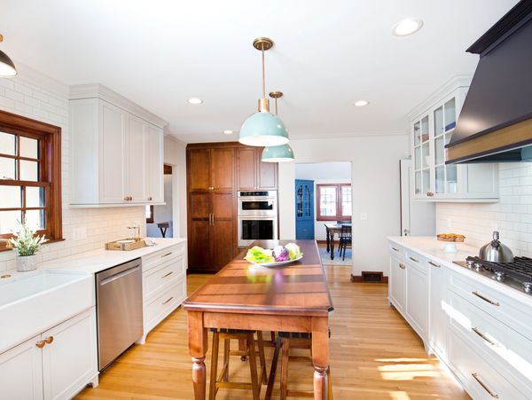 Bright and modern kitchen with wooden finishes and blue pendant lights.