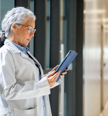 Hands using digital tools for clinical data management.