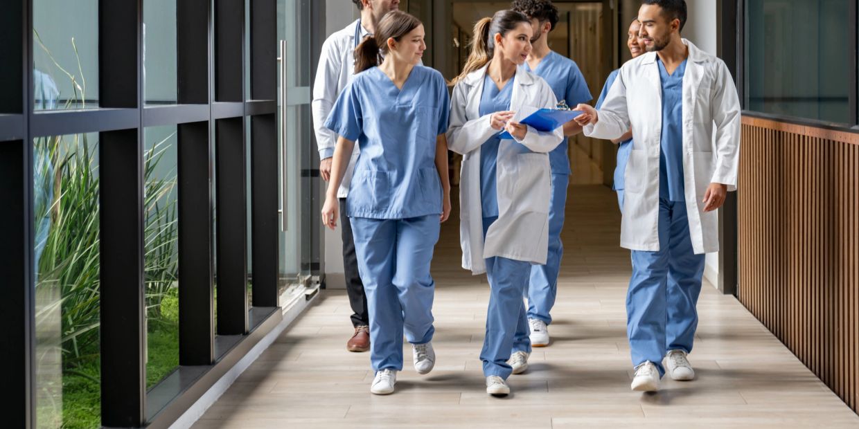 Medical professionals walking and discussing in hospital corridor.