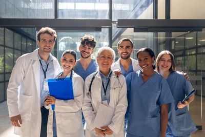 Group of diverse medical professionals smiling indoors.