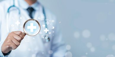 Doctor holding magnifying glass with medical cross and health icons.