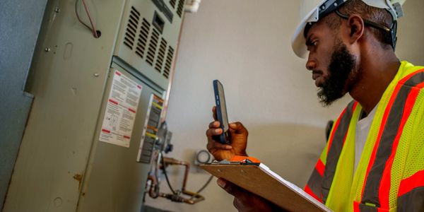 HVAC technician assessing system for optimal performance.