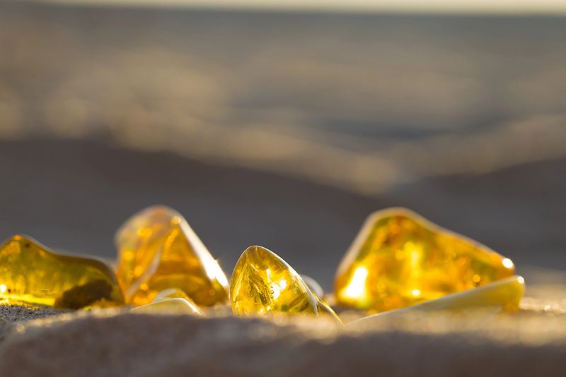 The warm light of sunset highlights amber's beauty on the beach in Koobrzeg, with each piece reflecting soft summer hues.