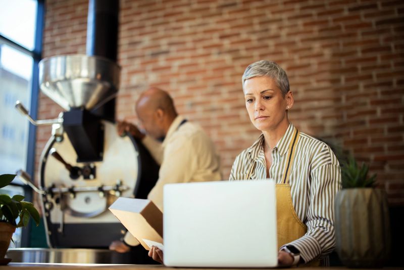 Coffee roasters managing their coffee shop, roasting coffee beans and taking online orders