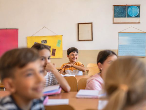 Boy smiling happily in a classroom.