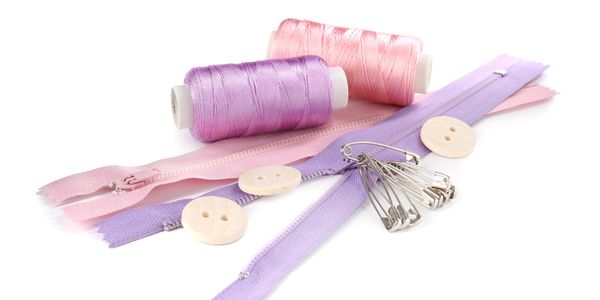 Sewing essentials including threads, zippers, buttons, and safety pins.