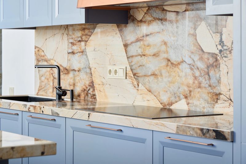This stylish kitchen showcases a stunning marble backsplash paired with modern and contemporary cabinetry design