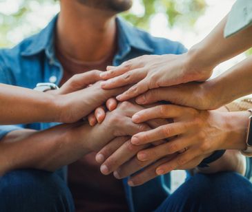 Multiple hands stacked together symbolizing unity and teamwork.