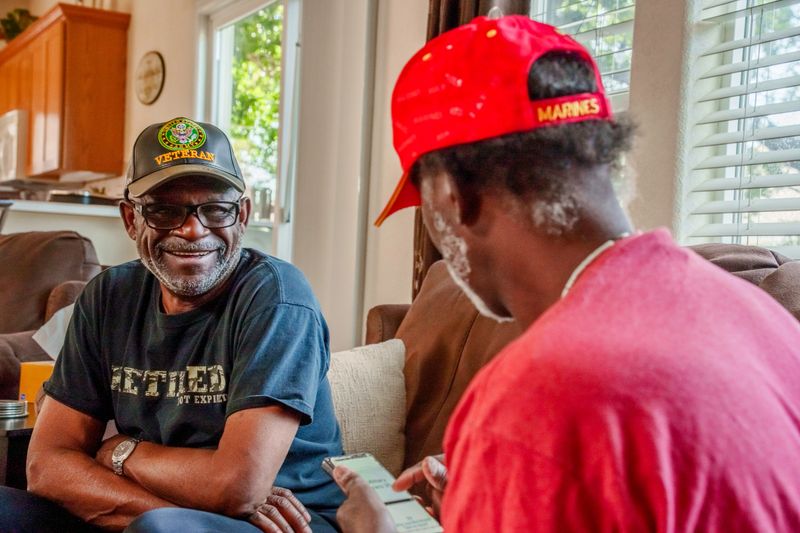 Military Veterans in Their Seventies Having a Casual Conversation in a Residential Living Room