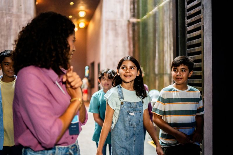 Young teacher walking and talking to students during field trip