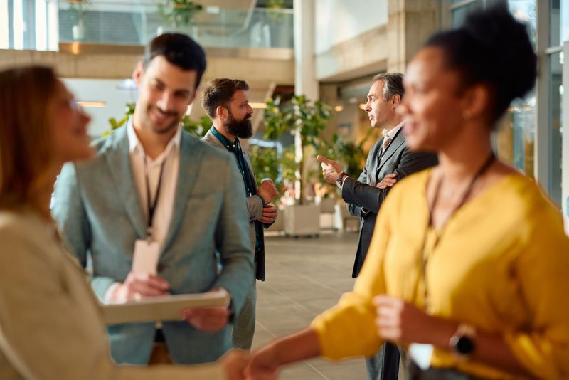 Business colleagues are networking and discussing during a corporate event, exchanging ideas and building professional relationships in the vibrant atmosphere of a modern office