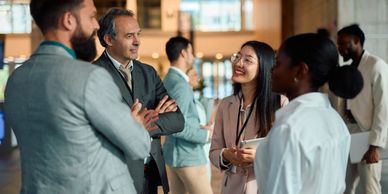 Diverse professionals networking and chatting at a business event.