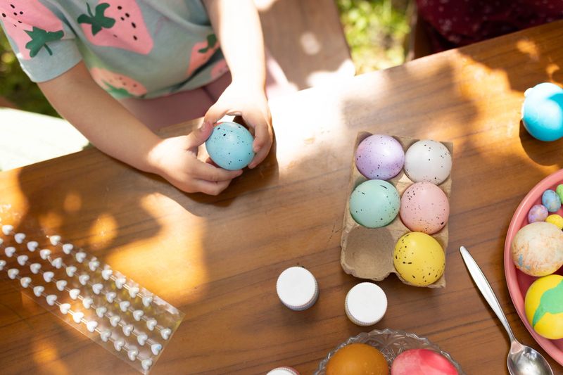 The child holding one ,blue Easter egg.
