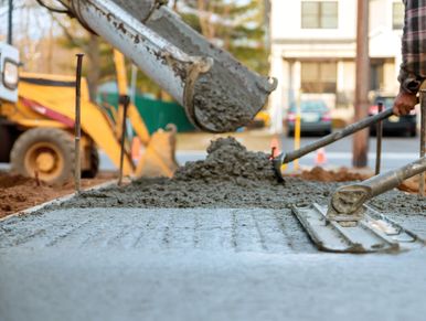 Workers pouring and leveling concrete for a construction project.