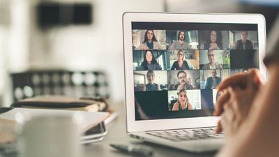 Person attending a virtual meeting on a laptop with multiple participants.
