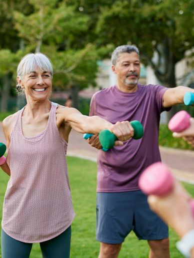 Seniors exercising with dumbbells outdoors