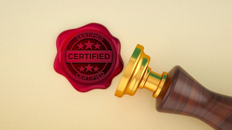 A shiny red wax Seal - Stamp, embossed with the word "CERTIFIED" and stars, signifies approval and authenticity. Next to the impression on beige Parchment lies the elegant stamper, featuring a Gold - Metal base and a polished Wood - Material Handle. This image is a powerful visual Metaphor for Quality Control, Validation, and official Verification. It evokes a sense of Tradition and Trust, making it perfect for concepts related to Business, Finance, Law, and Education. Whether representing a notarized Contract, a prestigious Award, a Diploma, or a first-class product Certificate, this seal conveys a message of Achievement, Reliability, and the highest standards.