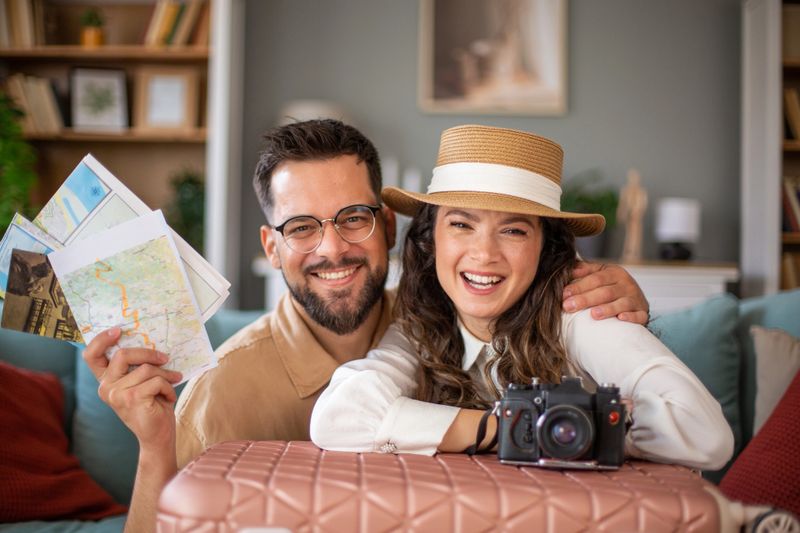 Happy tourists preparing for vacation, holding maps and camera, excited for adventure