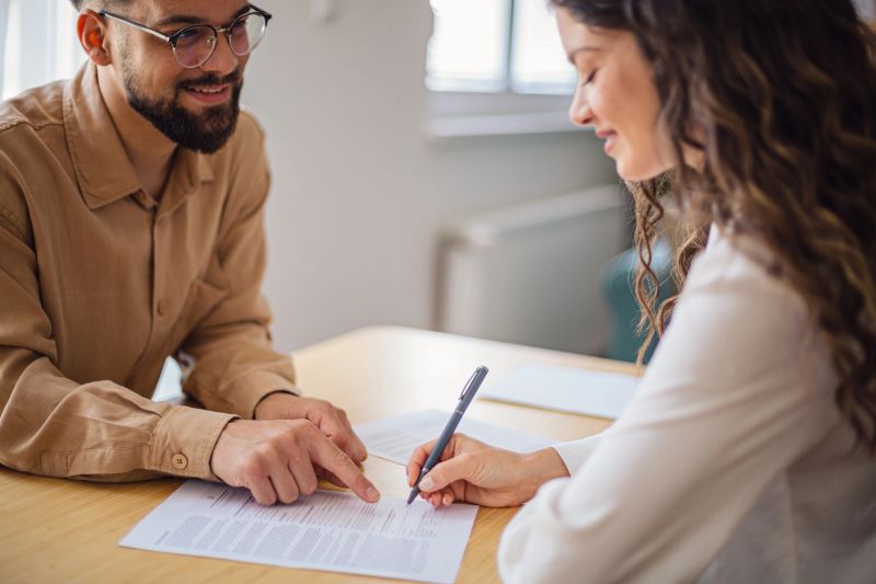 Financial advisor assisting client signing important documents at the office