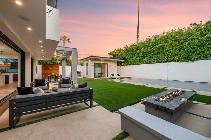 Twilight photo of a modern luxury home with pool, patio, and sleek architectural lines in a suburban setting