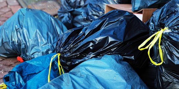 Pile of garbage bags on pavement.