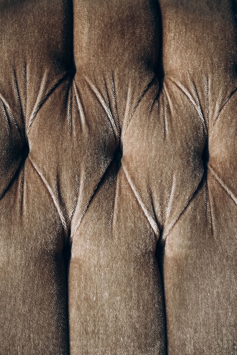 Detailed observation of a tufted upholstery fabric highlighting texture and pattern variations. The close-up captures the intricate design elements.