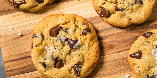 Chocolate chip cookies with sea salt on a wooden board.