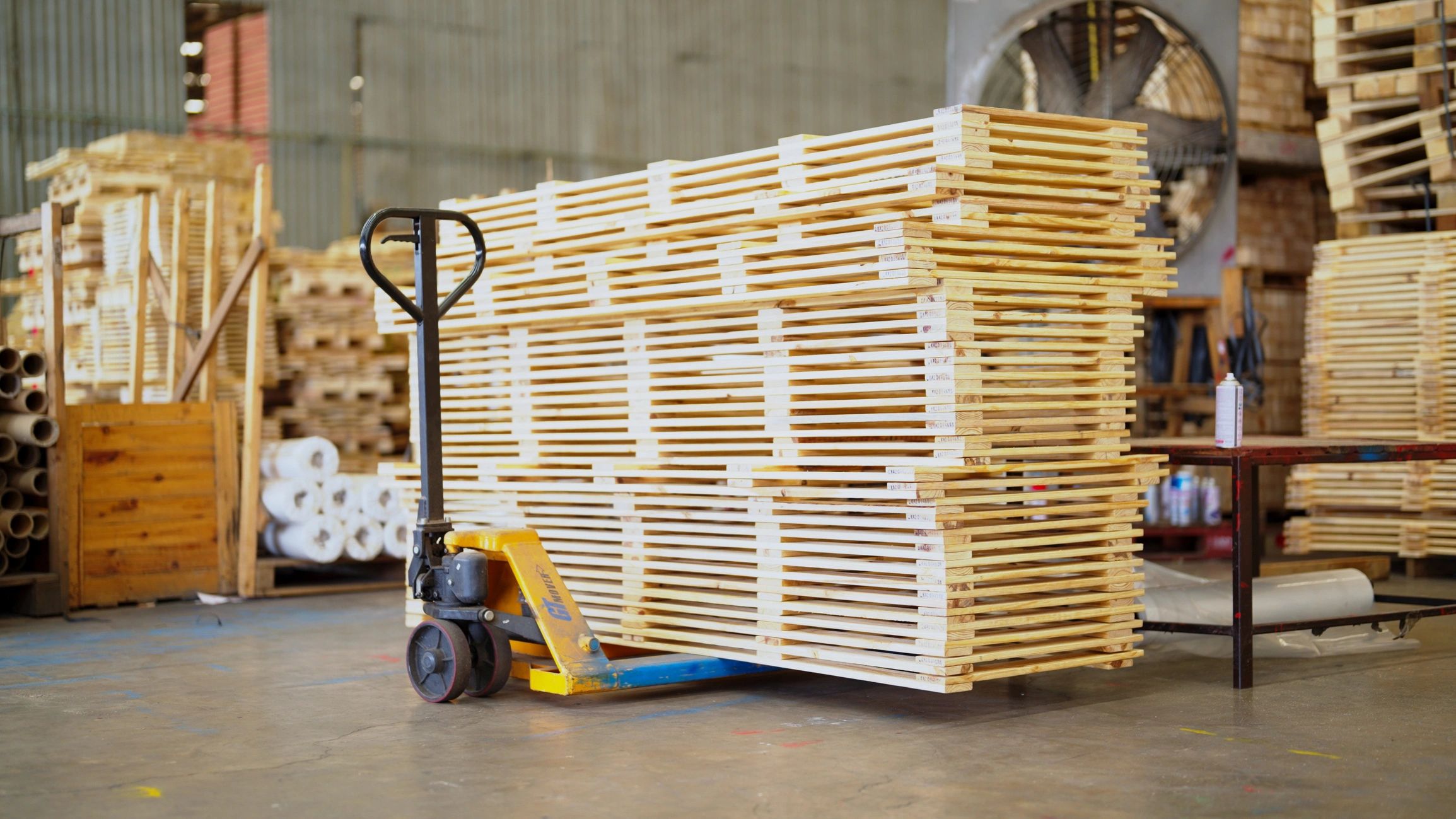 A big building has a lot of timber. Stacks of wooden boards