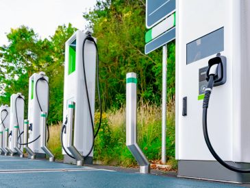 A row of electric vehicle charging stations in an outdoor setting.