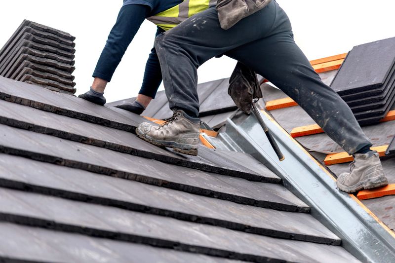 Construction worker carefully places roof tiles on a sloped surface while standing on top of a building  showcasing the effort involved in roofing work