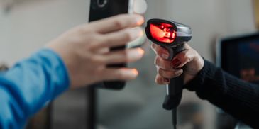 Person scanning membership barcode on phone.