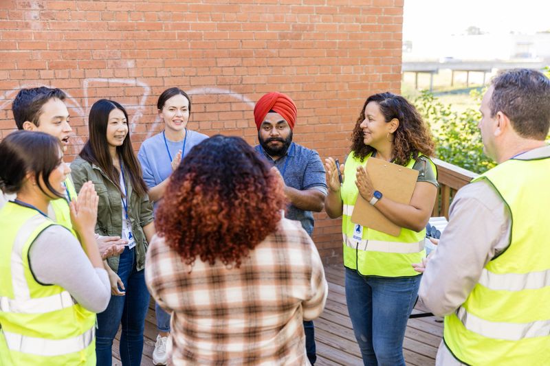 Diverse group of people showing support and teamwork.  Real people, casual clothing, happiness.
