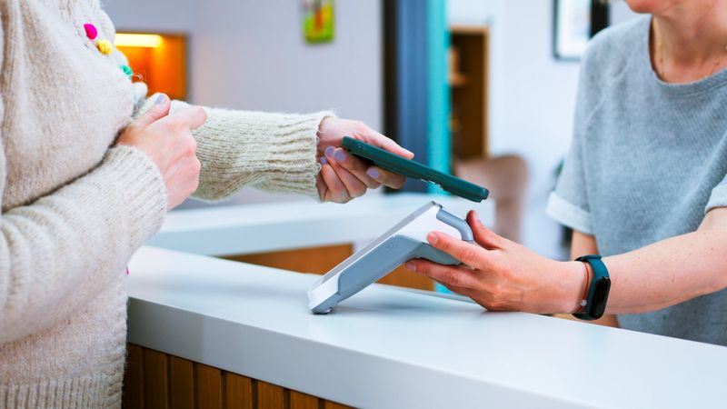 Patient is making mobile payment at a hospital reception