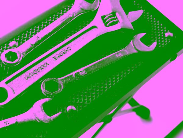 Set of wrenches and adjustable spanner on a textured surface.