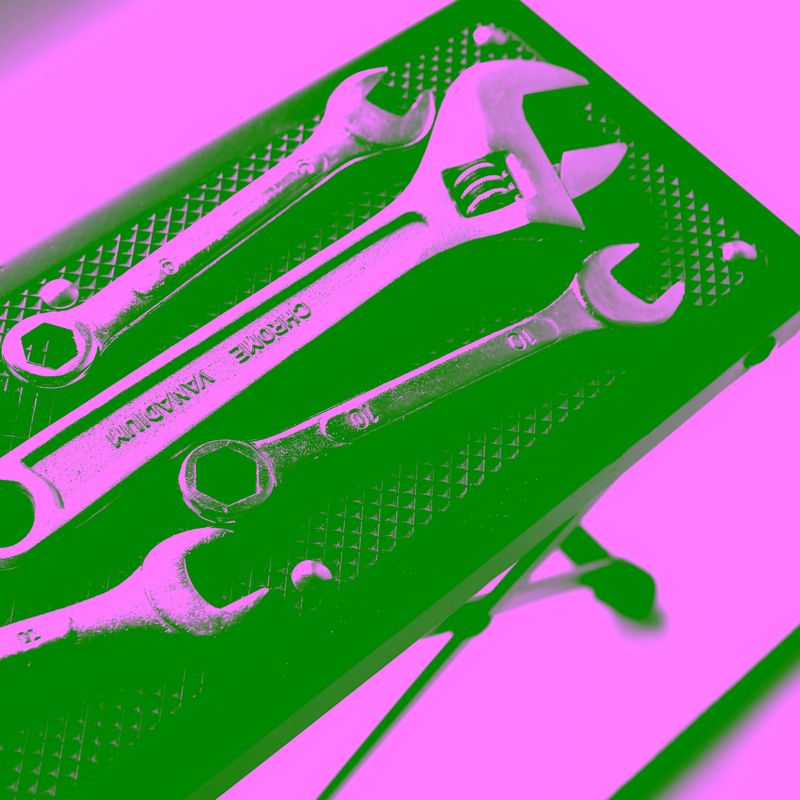 Steel wrenches and adjustable spanner on small tool stand isolated