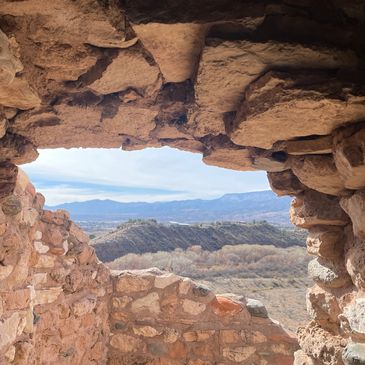 View through ancient stone ruins of distant mountains.