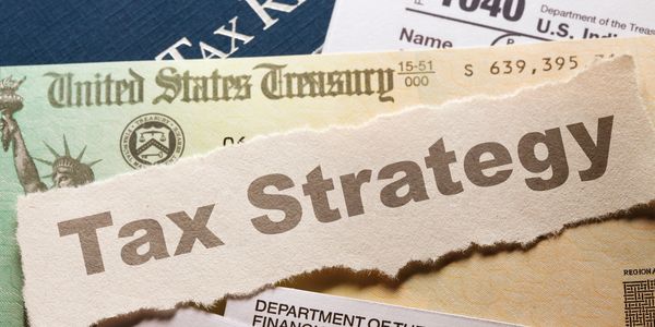 Documents with a torn paper saying 'Tax Strategy'.