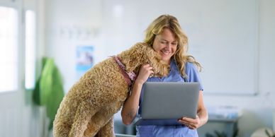 Vet smiling with a dog at the clinic.