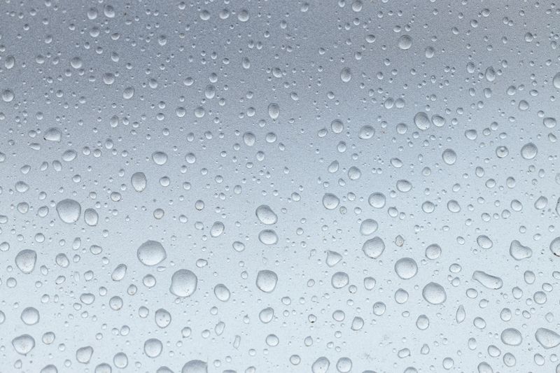 water drops on the silver metal surface, abstract background, macro drops after the rain, grey car after carwash