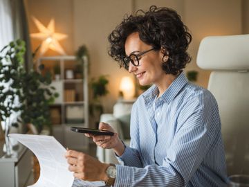 Woman scanning a document with her phone at home.