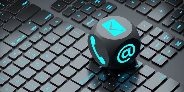 Black keyboard with glowing blue communication icons on a cube.