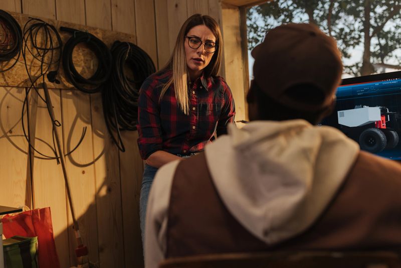 Agricultural robotics engineers collaborating on an innovative project in their workshop, utilizing technology and expertise for future advancements