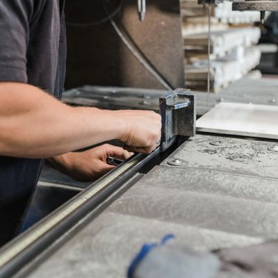 Person adjusting a measuring tool on a metal workbench.